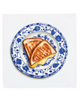 Two pieces of grilled cheese sandwich on a decorative blue and white plate with floral patterns on a tile.