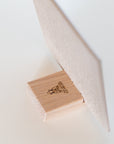 Wooden tile holder with The Dutch Tile Project logo holding a ceramic tile on a light background