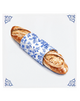 A French baguette on a Delft Blue ceramic tile with decorative corner ornaments