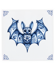 A little bat on a Delft Blue ceramic tile with decorative corner ornaments