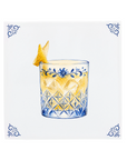 An amaretto sour cocktail on a Delft Blue ceramic tile with decorative corner ornaments