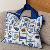 Gerecyclede Delfts Blauwe tote bag van The Dutch Tile Project, voorkant met een raster vol Hollandse icoontjes en een rood-wit-blauwe vlag op het hengsel
