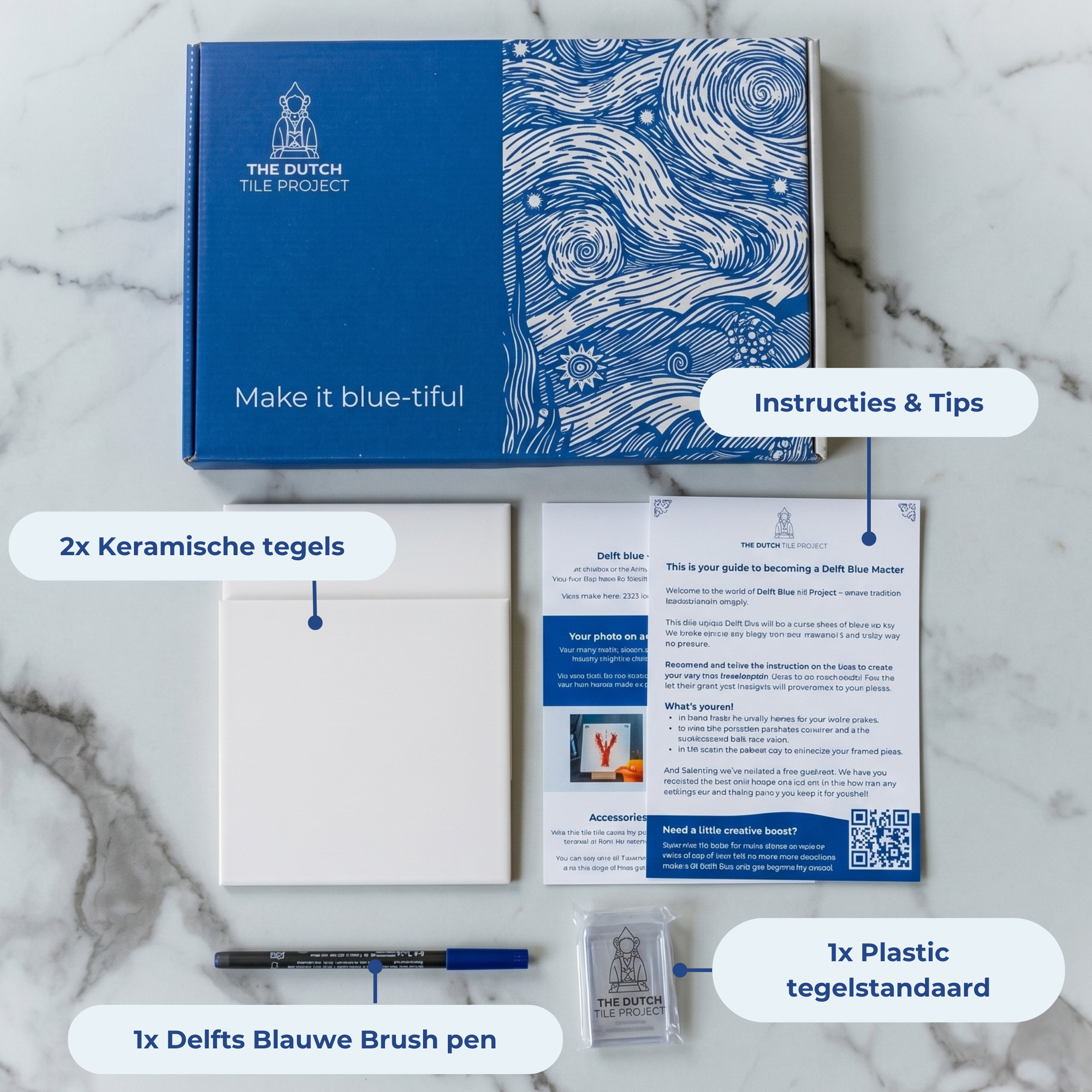 DIY kit contents displayed on a marble surface, including two ceramic tiles, a bent brush, an acrylic stand and instruction cards. [market:nl]