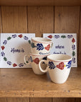 Two Boerenbont ceramic tiles featuring the quote "Home is where family is", surrounded by colourful Dutch floral motifs and matching Boerenbont tableware. [market:!nl,!de,!at,!fr]