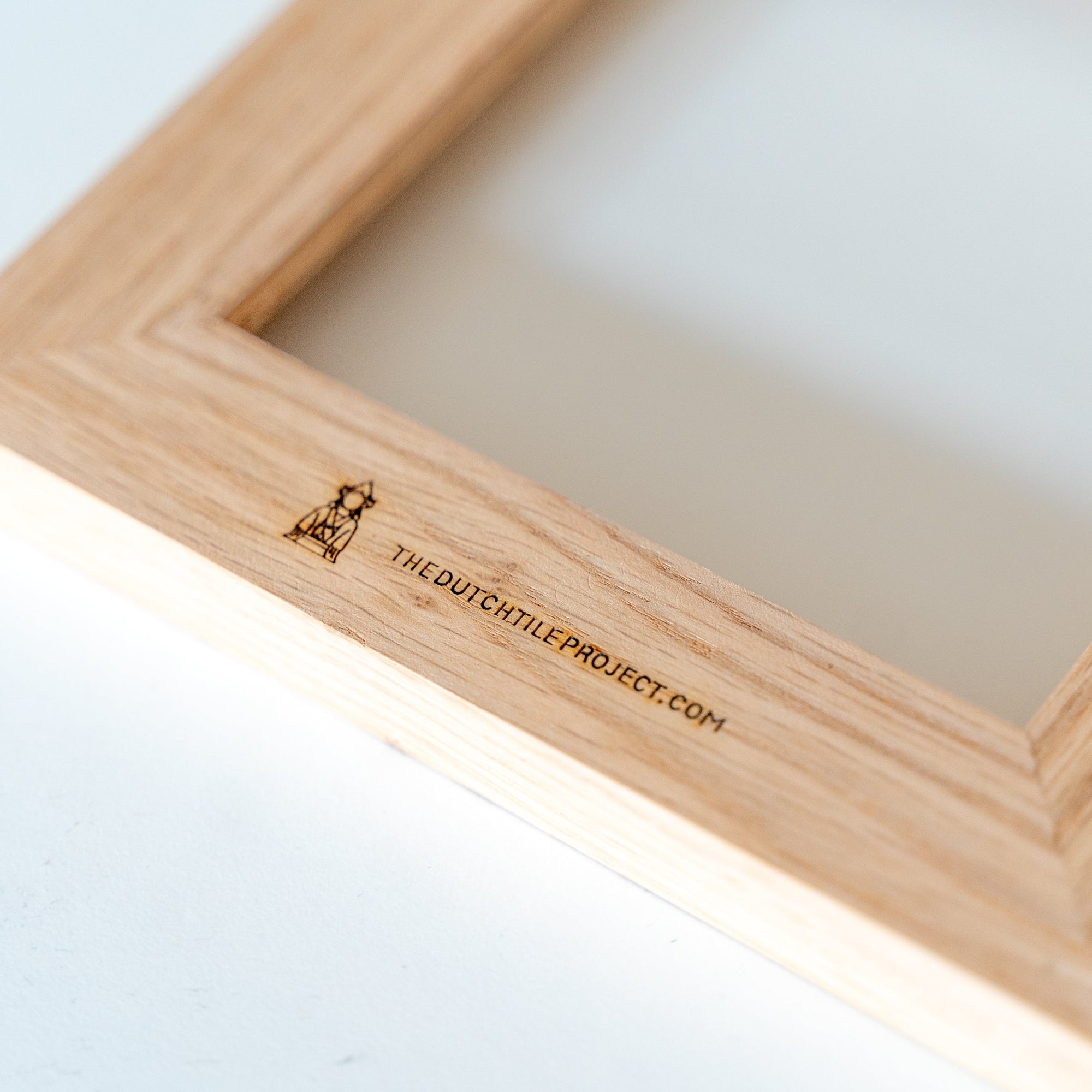 Back view detail of a horizontal wooden tile frame, showing The Dutch Tile Project logo and website.