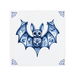A little bat on a Delft Blue ceramic tile with decorative corner ornaments