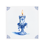 A lit candle on a Delft Blue ceramic tile with decorative corner ornaments